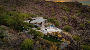 A modern house with a pool, surrounded by rocky terrain and greenery. - Camelback Valley / Mountain Views, Pool & Hot Tub (Paradise Valley)