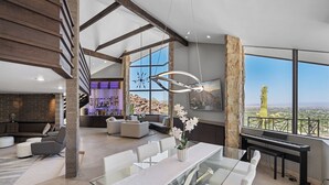 A spacious living area with a dining table, sofas, and a piano. - Camelback Valley / Mountain Views, Pool & Hot Tub (Paradise Valley)