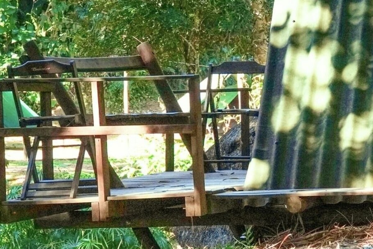 A wooden deck with a bench and a rope barrier.