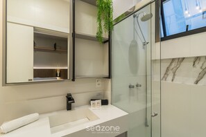 A modern bathroom with a glass shower enclosure, a white sink, and a mirror above it. - Apt w/ Barbecue Grill 900 m From the Beach Epd0702 (Porto Belo)