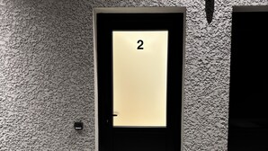 Un ascenseur moderne avec un mur texturé et une porte portant le numéro 2.