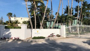 A gated residential area with palm trees, a white fence, and a building labeled "South Fleetwood 9". - FERN COTTAGE:  Beautiful Studio, Only Steps Away From Grace Bay Beach and Strip! (Grace Bay)