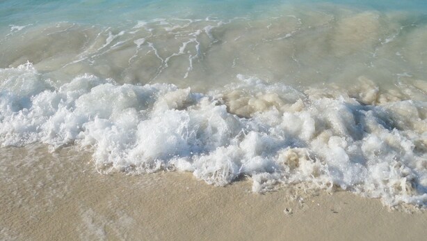 A beach with clear turquoise water and white waves. - FERN COTTAGE:  Beautiful Studio, Only Steps Away From Grace Bay Beach and Strip! (Grace Bay)