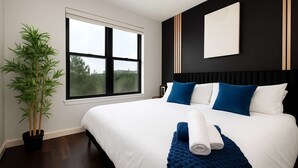 A modern hotel room with a large bed, a potted plant, and a window with a view. - 2BR Oasis w/ Gym, Parking Near Rvrwalk &Dome (San Antonio)