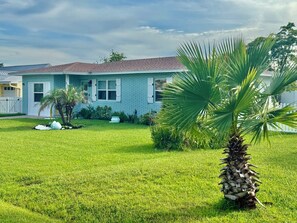 A residential house with a well-maintained lawn and a palm tree. - Ocean Breeze Retreat – Walk to the Beach! (St. Augustine)