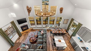 Amplia sala de estar con un sofá grande, una mesa de comedor y una zona de cocina.
