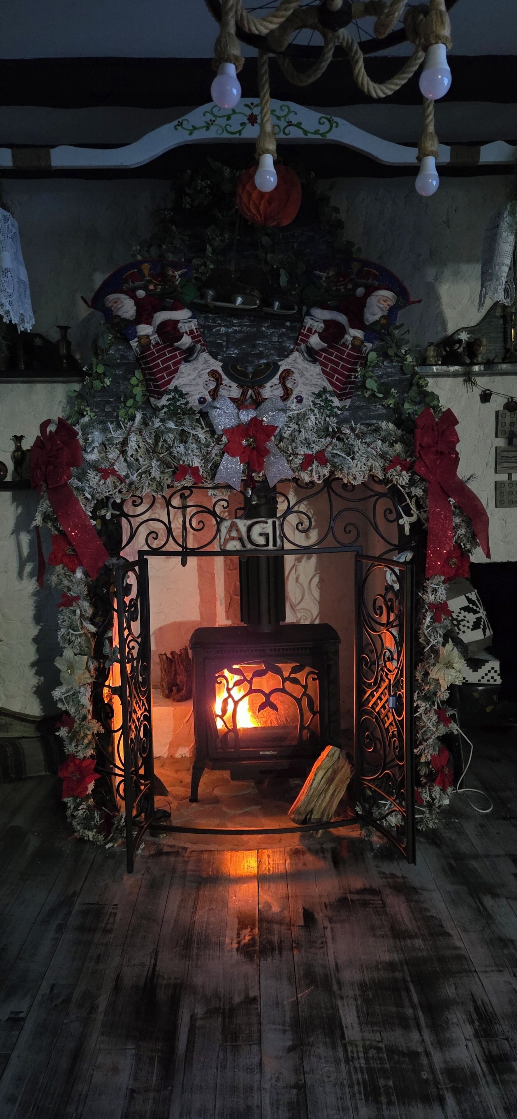 Un rincón acogedor con chimenea, un faldón de leña y decoración festiva.
