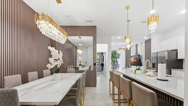 A modern kitchen with a marble countertop, stainless steel appliances, and pendant lighting. - Paradiso Grande 5BR Home w Pool, Mario Game Room (Orlando)