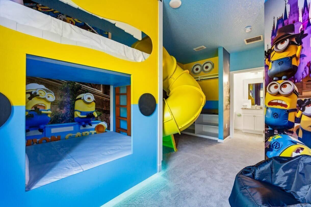 A children's play area with a slide, a playhouse, and Minion-themed decorations.