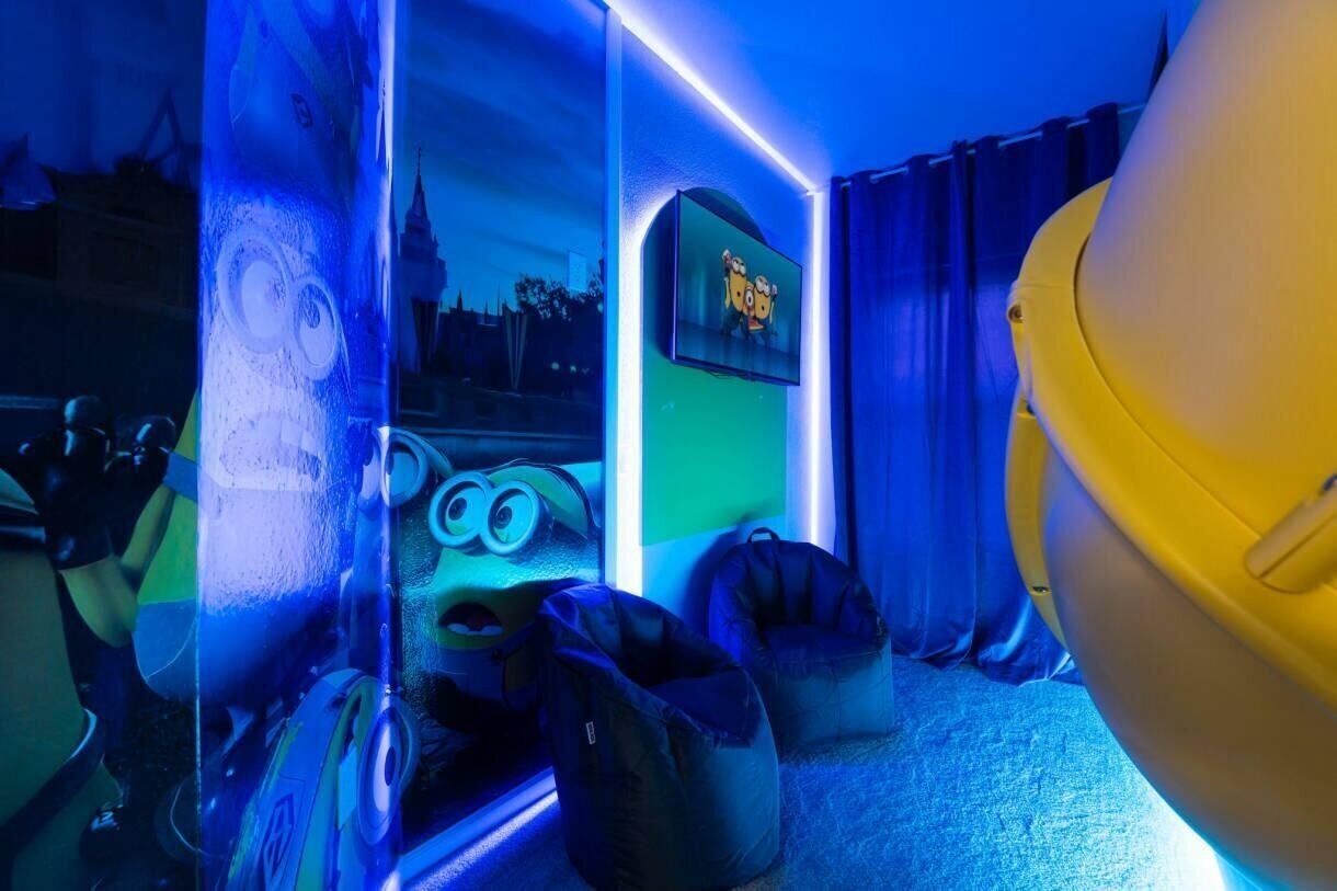 A room with a large window, a flat-screen TV, and a yellow object on the right.