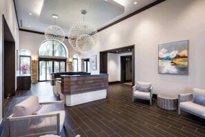 Eine moderne Lobby mit Empfangstresen, Sitzgelegenheiten und Kunstwerken an den Wänden.