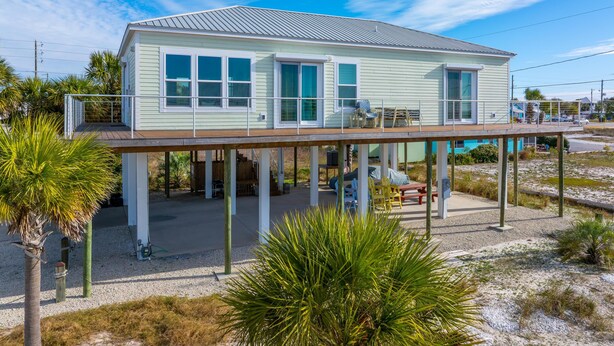 A two-story house with a covered deck, a front porch, and a swimming pool. - Abalonian House (Port St. Joe)