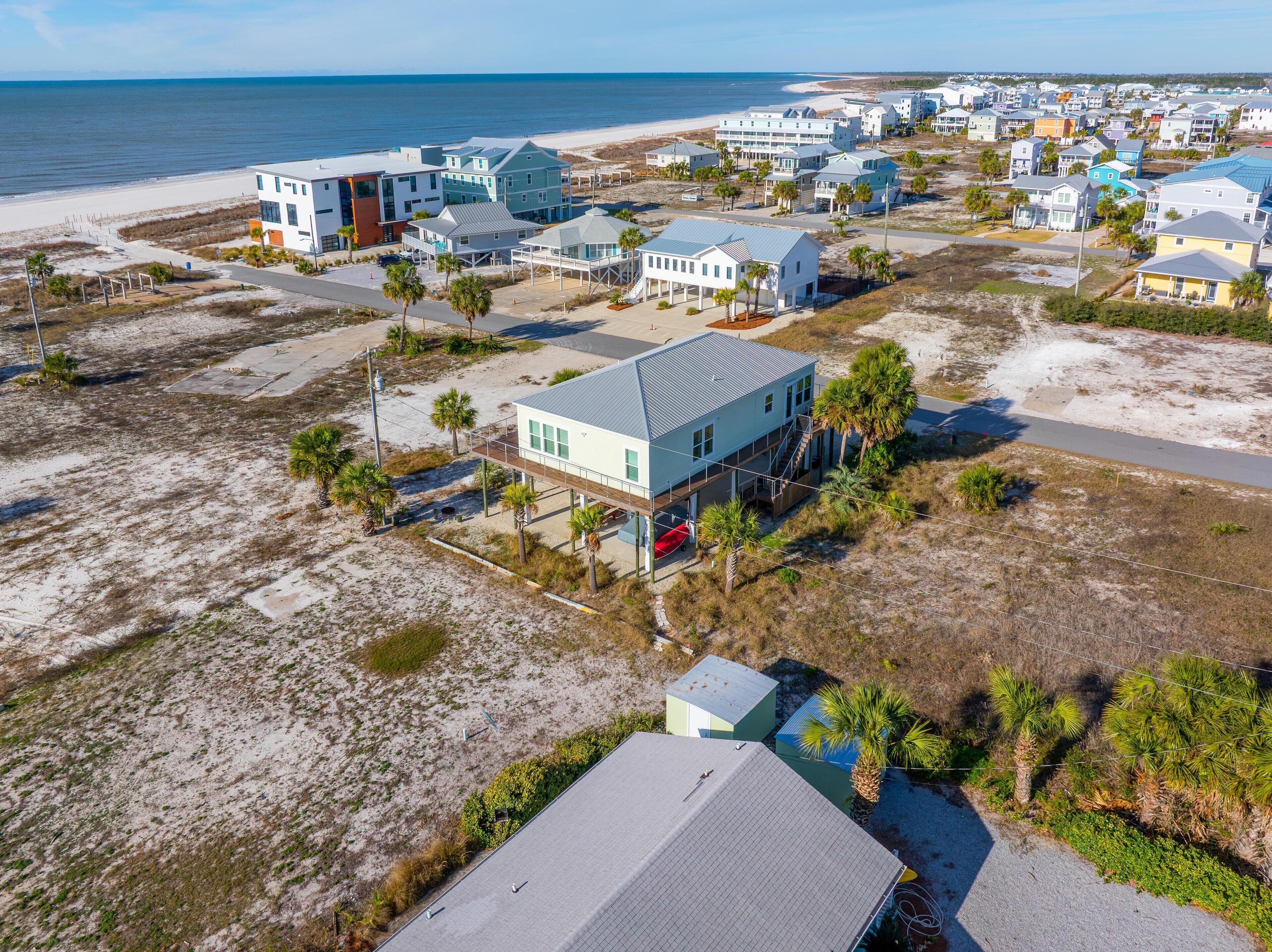 Una zona residencial costera con casas, una playa y una vista despejada del océano.