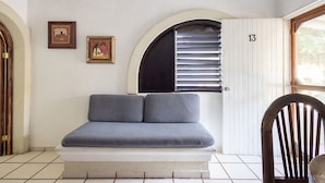 Een kamer met een bed, een deur met het nummer 13 en een raam met zonwering.