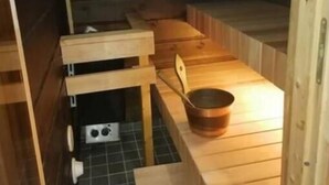Ein Saunaraum mit Holzbänken, einem kleinen Tisch und einem Fenster.