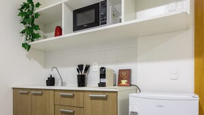 Une cuisine équipée d’un four à micro-ondes, d’une machine à café et d’un réfrigérateur.