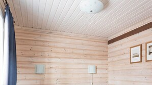 A room with two beds, a ceiling light, and two bedside tables. - Pyry Cottage (Muurame)
