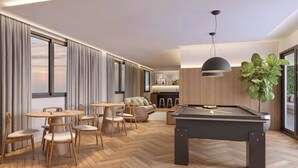 Una sala de estar moderna con mesa de billar, muebles de madera y ventanas grandes.