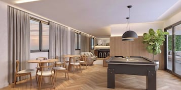 A modern living room with a pool table, wooden furniture, and large windows.