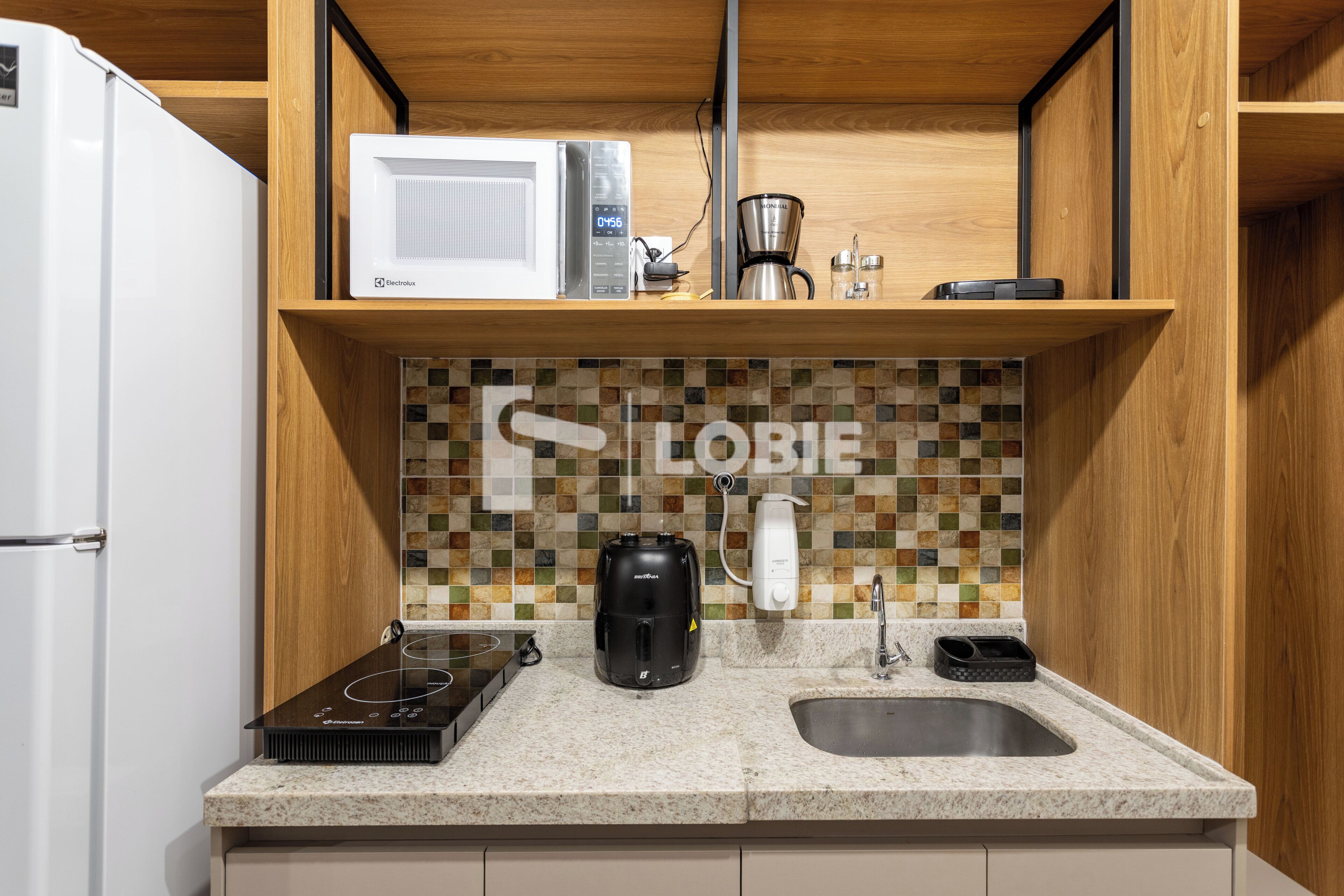 Eine Küche mit Mikrowelle, Kaffeemaschine, Toaster und Spüle.