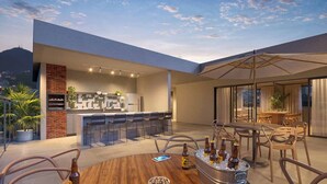 Un área de comedor exterior moderna con barra, asientos y vistas del horizonte de la ciudad.