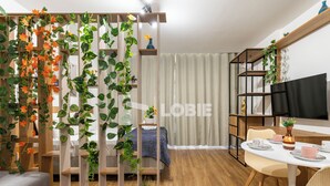 Un espacio habitable moderno con una cama, una zona de comedor y un televisor.