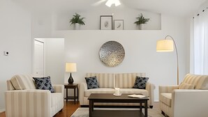A modern living room with two sofas, a coffee table, and a floor lamp. - Prime Location! 3bd/2ba Villa (Kissimmee)
