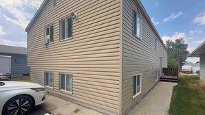 A two-story house with a sloped roof, multiple windows, and a front porch. - Workman’s Rest Pt. 2 – Quiet Upstairs 2BR for Working Travelers (Gillette)