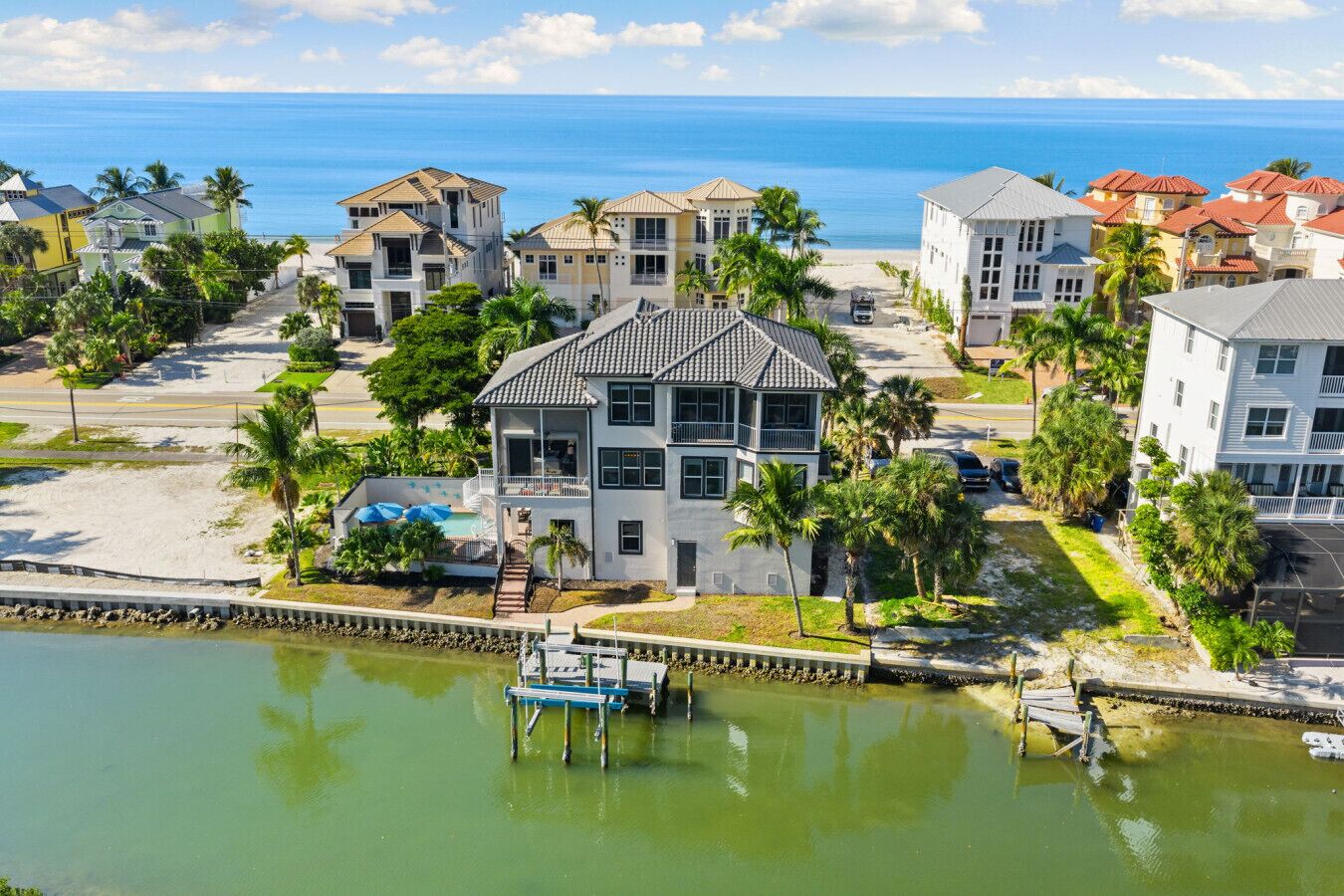 Uma área residencial à beira-mar, com casas, um cais e uma praia.