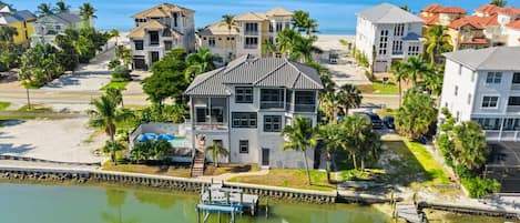 Uma área residencial à beira-mar, com casas, um cais e uma praia.