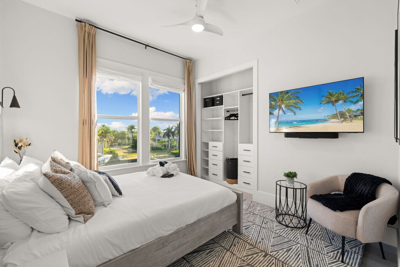 Une chambre à coucher avec un lit, une télévision, une chaise et une armoire.