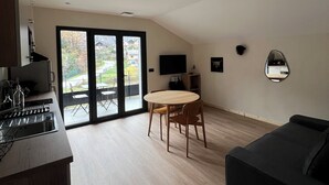 Une cuisine moderne dotée d’un four encastré et d’un coin repas avec une table ronde et des chaises.