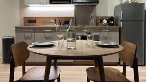 Une cuisine moderne avec une table de salle à manger ronde, deux chaises et un réfrigérateur.