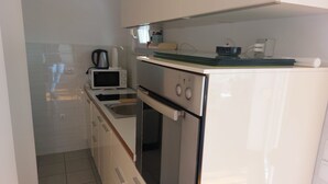 A compact kitchen with a microwave, toaster, sink, and a small oven. - Villa Nižić Makarska - One Bedroom Apartment With Balcony (Marina) (Makarska)