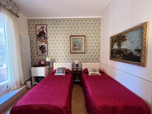 A hotel room with two beds, a desk, a radiator, and a window with curtains. - B&B Beroni a Venezia (Venice)