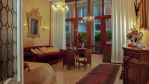 Ein Zimmer mit einem roten Sofa, einem Holztisch und einer Kristallleuchter.