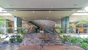Une entrée moderne, avec un escalier à volutes, des marches en pierre et des plantes en pot.