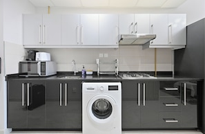 A modern kitchen with a Bosch washing machine, a microwave, and a sink. - 1306 Bloomfields Casual STU Elite Tower  (Dubai)