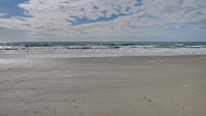 A beach with a clear sky and ocean waves.