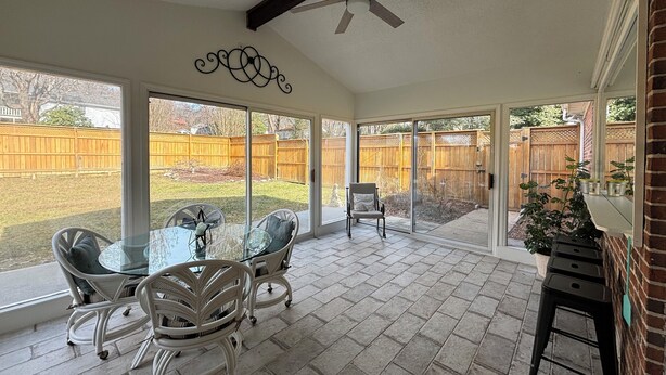 A covered patio with a glass table and chairs, a ceiling fan, and a view of a backyard with a wooden fence. - Sleeps 10 close to all attractions! BMSpeedWay, DT, Casino, Holston & Boone Lake (Bristol)