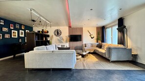 A modern living room with a sofa, a coffee table, a TV, and a guitar. - LOFT ROUEN (Rouen)