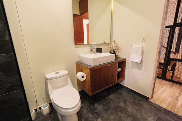 Une salle de bain moderne avec des toilettes, un lavabo et un miroir.