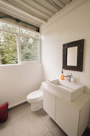 Ein Badezimmer mit Waschbecken, Spiegel und Toilette.