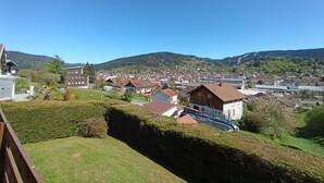 Un quartier résidentiel avec des maisons, une piscine et, au loin, un paysage vallonné.