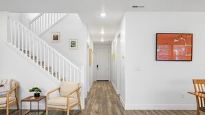 Un interior moderno con una escalera, suelo de madera y decoración minimalista.