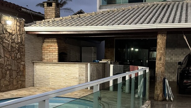 Une maison moderne dotée d’une piscine, de murs en pierre et d’un toit recouvert de tuiles.