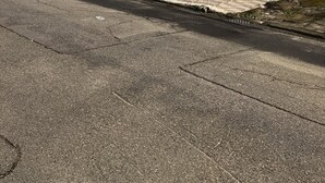 Un bâtiment doté d’une porte de garage, d’un mur en pierre et d’une allée pavée.