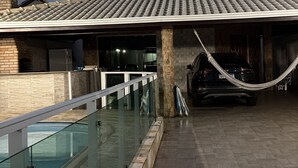 Un bâtiment moderne doté d’un toit plat, de grandes fenêtres et d’un espace de stationnement couvert.
