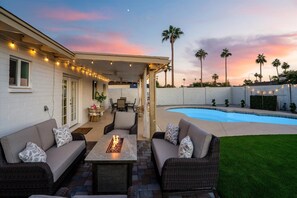 A patio area with a pool, outdoor furniture, and string lights. - Heated Pool & Hot Tub Near Top Golf Courses (Tempe)
