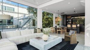 A modern living room with a sofa, coffee table, and dining area. - Pool, Putting Green, Game Room, Rooftop Bouldin Collective 902a by Avantstay (Austin)
